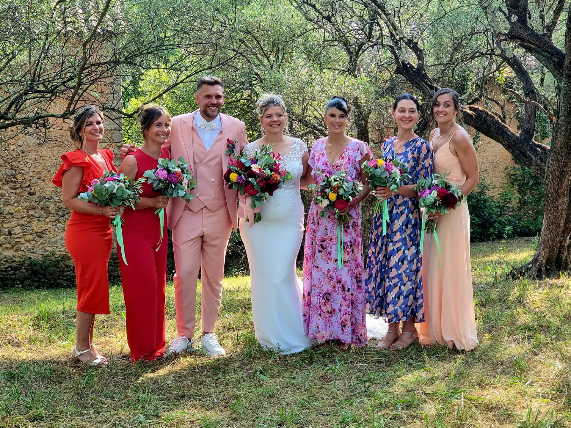 Mariés et cortège avec bouquets fleuris dans un jardin de Provence